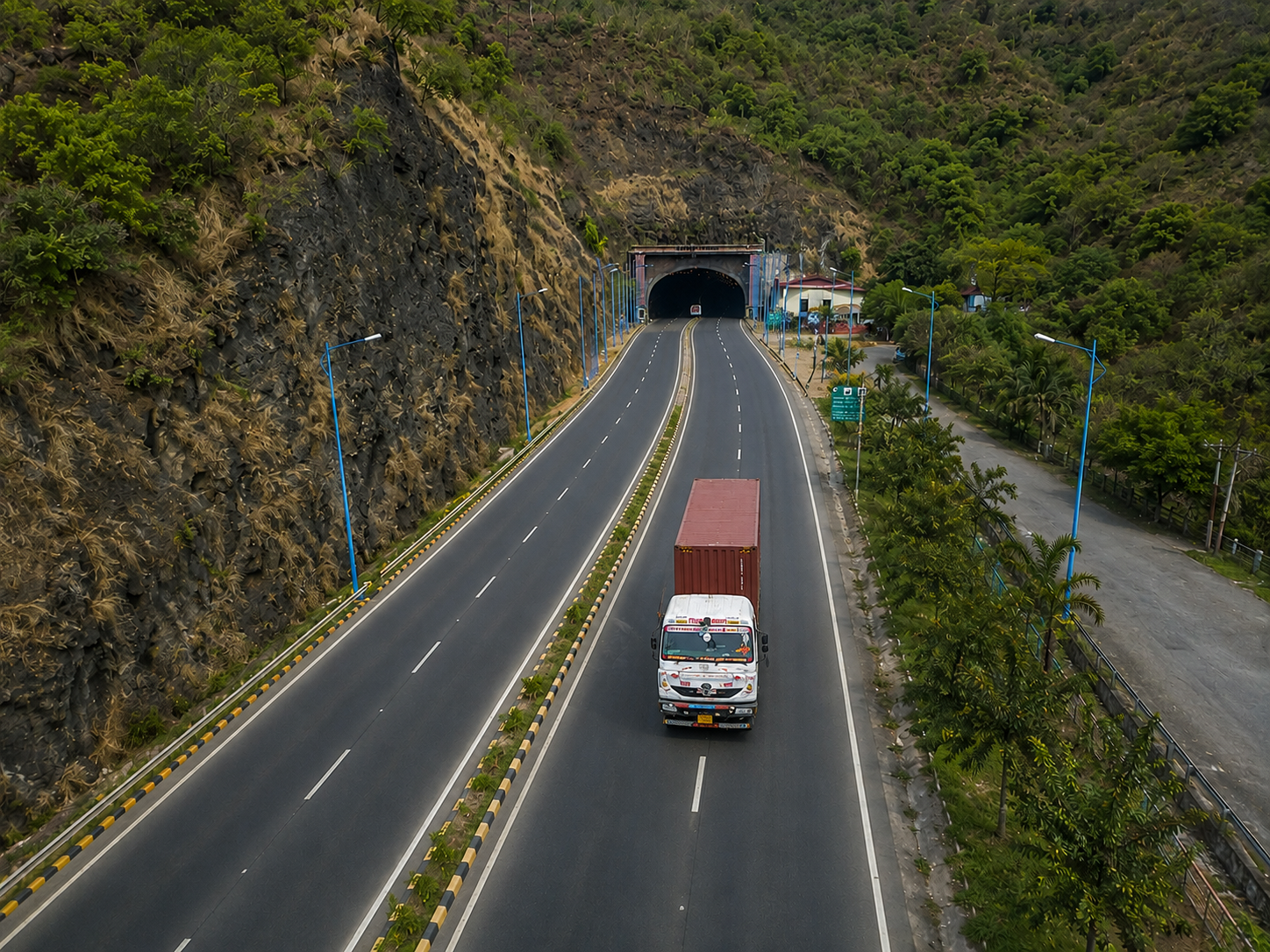 Aerial view of a red container truck on a mountain highway