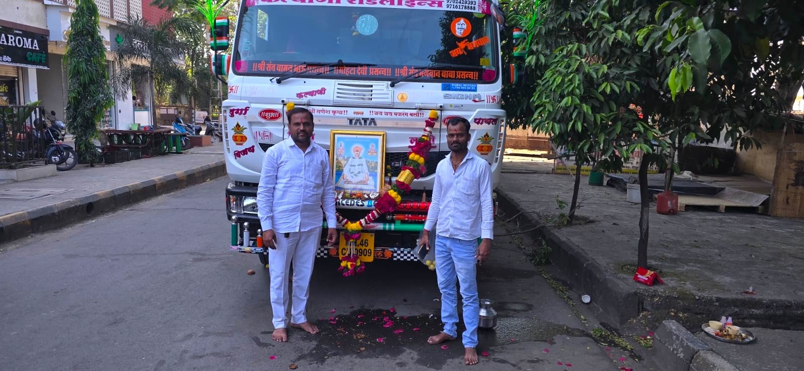 Two men standing with a new Kalyani Roadlines Tata truck